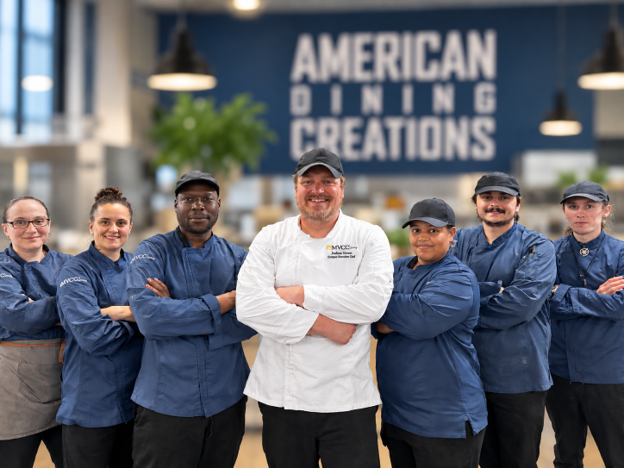 Team of chefs and cooks standing together in a group photo.